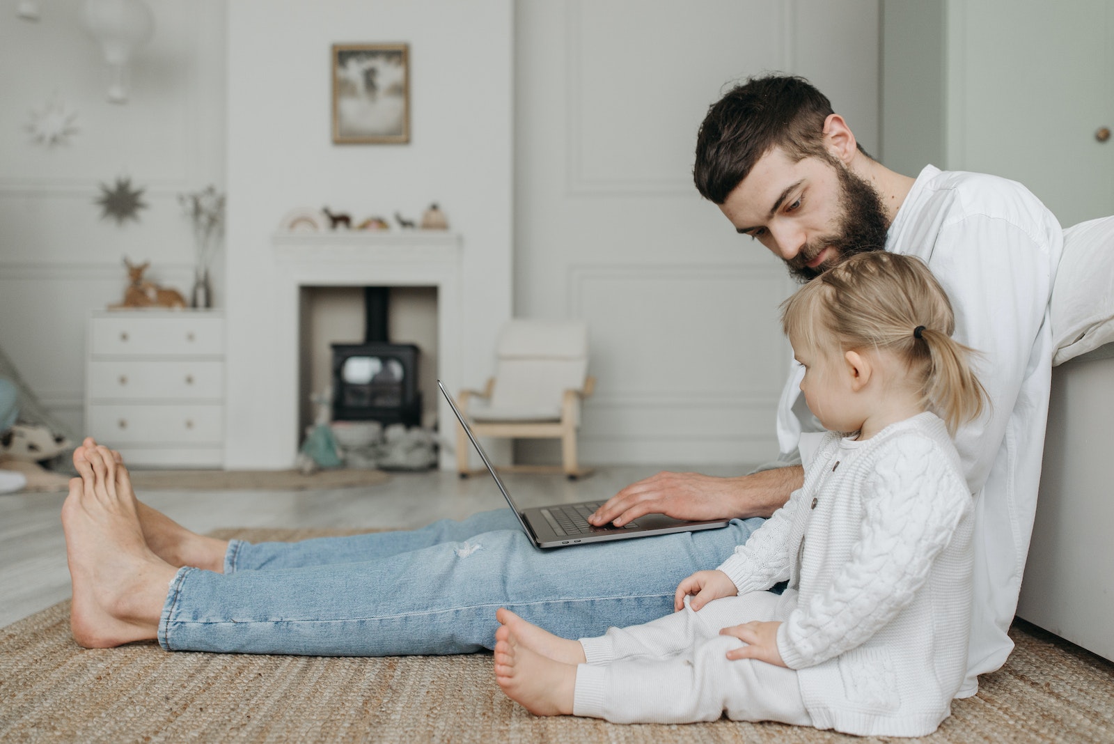 A Child Sitting Beside His Working Father